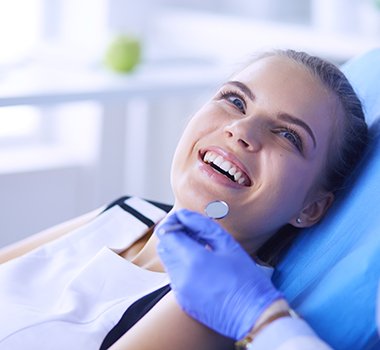 man smiling while sitting in dental chair 