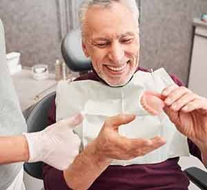 Patient in Landrum smiling at dentist after getting dentures