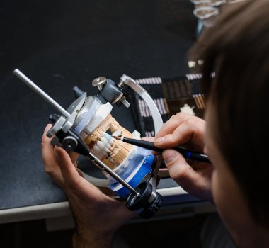 A dental lab technician creating dentures