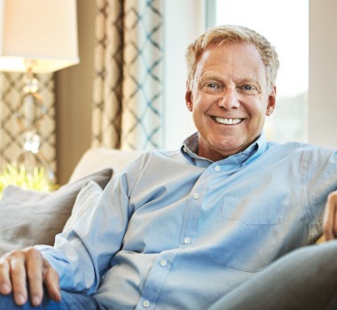 A smiling man sitting on a couch