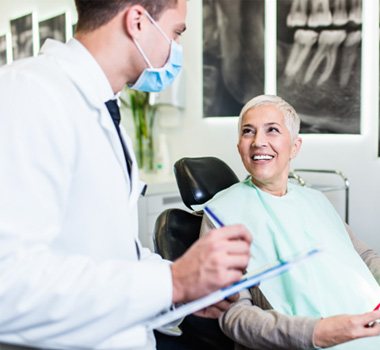 Dentist taking notes while talking with patient