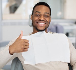 Happy male dental patient making thumbs-up gesture