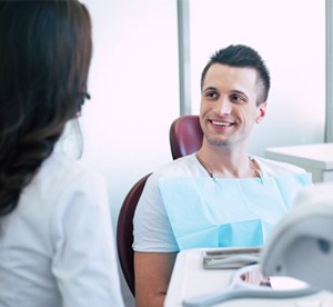 Smiling patient talking with dental team member