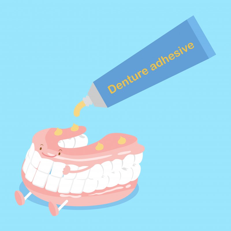 A cute cartoon denture receiving denture adhesive