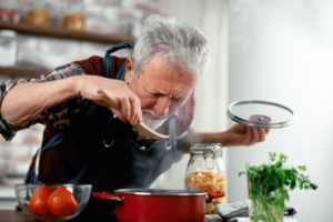 Senior man taste-testing his cooking