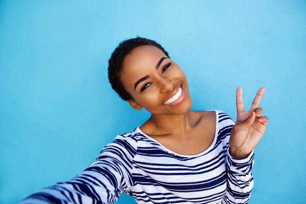 A woman with a beautiful smile taking a selfie.